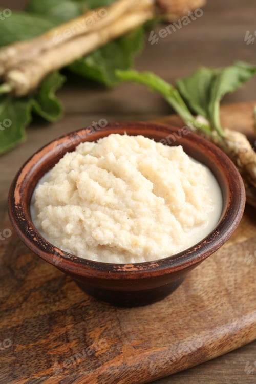 Preview: Tasty horseradish sauce and roots on wooden table, closeup