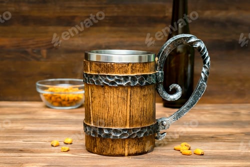 Preview: Big brown mug of beer,ale bottle and crispy snacks, pretzels, corn, nuts in bowl on wooden table