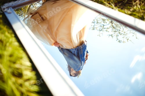 Preview: Portrait of a beautiful bride through mirror. Wedding concept. Stylish wedding. Great sunset light.