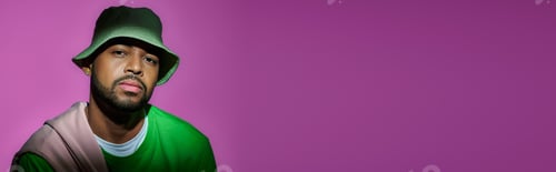 Vista previa: handsome bearded man in green panama on purple backdrop looking at camera, fashion concept, banner