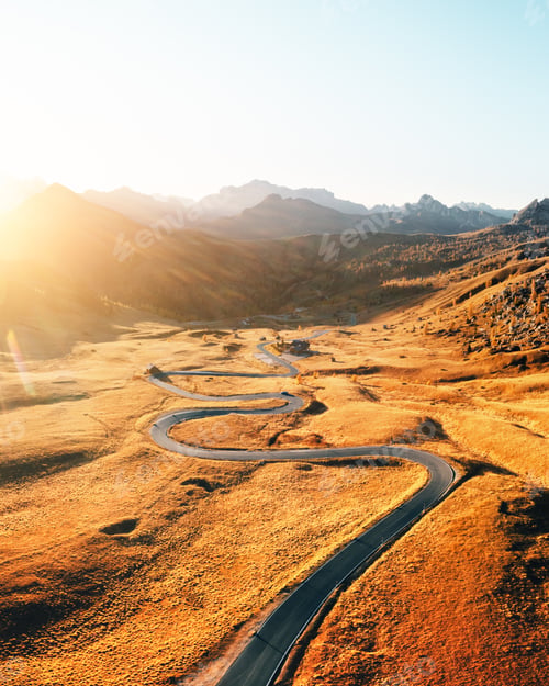 Preview: Incredible aerial view on winding road in autumn mountain valley at sunset