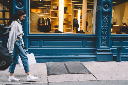 Preview: Woman walking on street with shopping bags