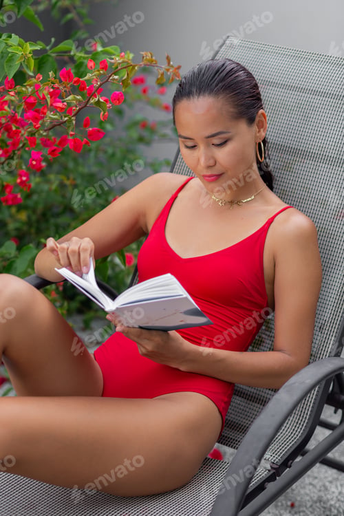 Preview: Asian woman in swimsuit relax by pool on sunbed, read book