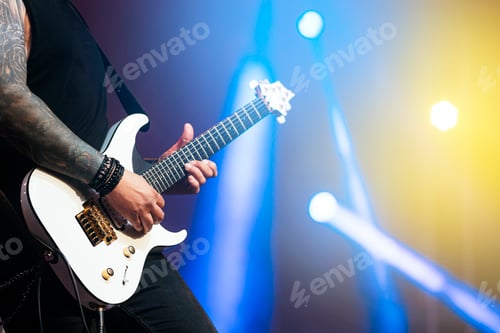 Preview: Guitarist Playing White Electric Guitar Under Blue Lights