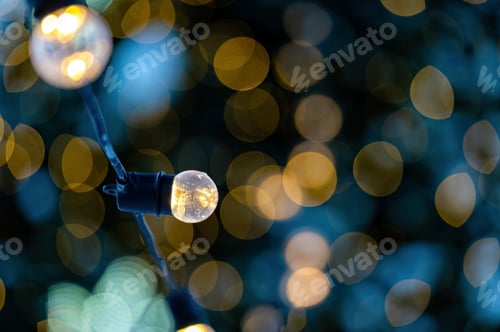 Preview: garland of light bulbs on defocused festive lights background, shallow depth of field, copy space