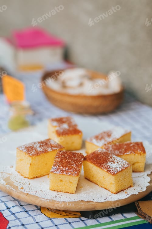 Preview: Sweet baked polenta with powdered sugar over them on a wooden plate