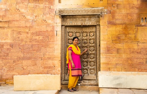 Preview: Woman tourist in front of old wooden door, Jaisalmer, India