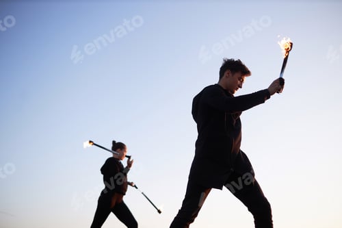 Preview: Two Fire Show Performers Dancing with Flames on Clear Sky