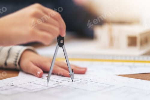 Preview: An architect using compass to draw and measure shop drawing in office