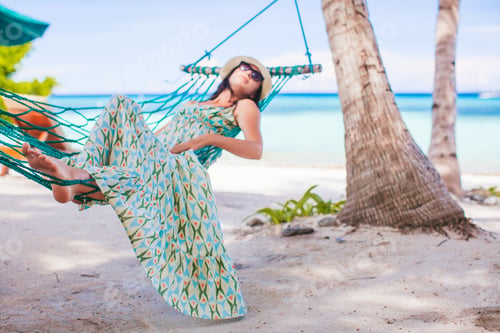 Preview: Adorable girl on tropical vacation relaxing in hammock