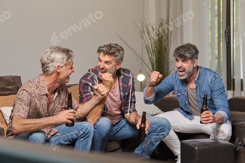 Preview: Cheerful mature friends with beer watching TV