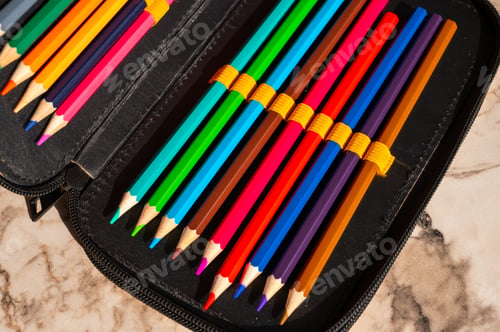Preview: multi-colored pencils in a schoolboy's pencil case
