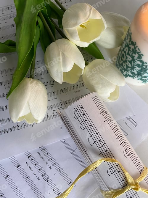 Preview: Music sheets and white tulips with candle