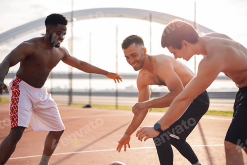 Preview: Three friends having fun playing basketball outdoors