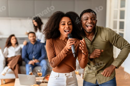 Preview: Friends laughing and singing together sharing a mic