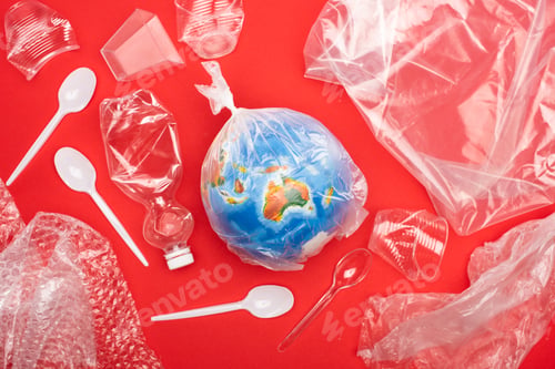 Preview: Top view of globe in plastic bag with garbage around isolated on red, global warming concept