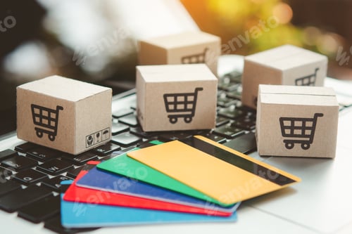 Preview: Shopping online. Credit card and cardboard box with a shopping cart logo on laptop keyboard.