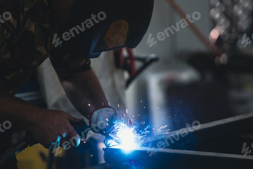 Preview: Industry worker welding iron pieces at work