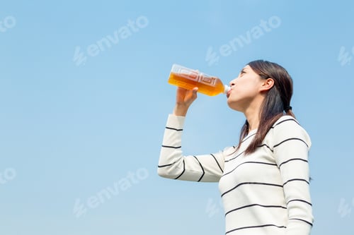 Preview: Woman drinking bottle of tea