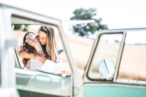 Preview: two attractive woman who looks at the map next to her van