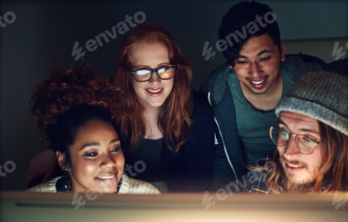 Preview: Shot of a business team looking at a computer screen on a night shift at the office