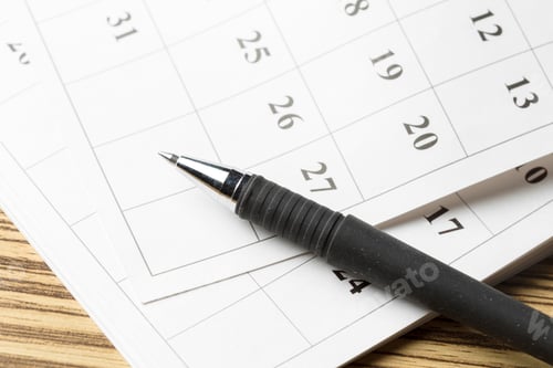 Preview: Planning schedules with a pen on a calendar for effective time management