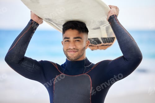 Preview: This is my happy place. Shot of a young man holding a surfboard at the beach.