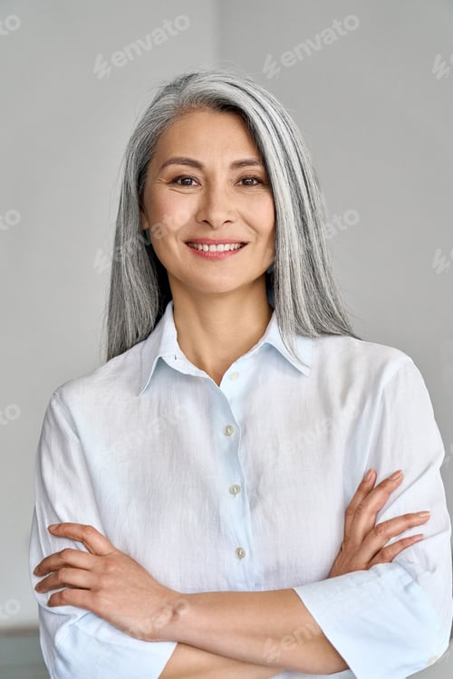 Preview: Vertical portrait of mature 50 years Asian business woman on grey background.