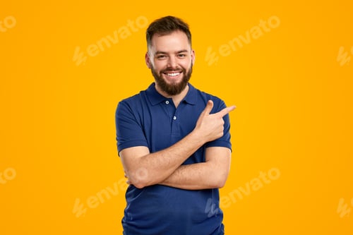 Vista previa: Hombre alegre señalando a un lado en el estudio