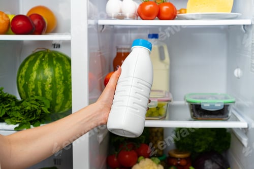 Preview: Female hand taking bottle of milk from a fridge