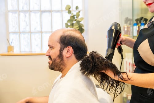 Preview: Hairdresser drying a washed capillary prosthesis of a client