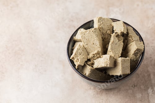 Preview: Halva slices in a bowl. Oriental sweetness. Copy space.