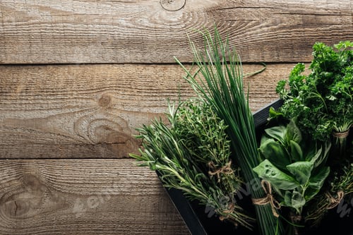 Preview: top view of green thyme, spinach, parsley, rosemary and green onion in box on wooden weathered table