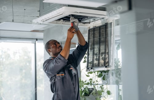 Preview: High up, fixing the ventilation. Repairman is indoors in the modern office