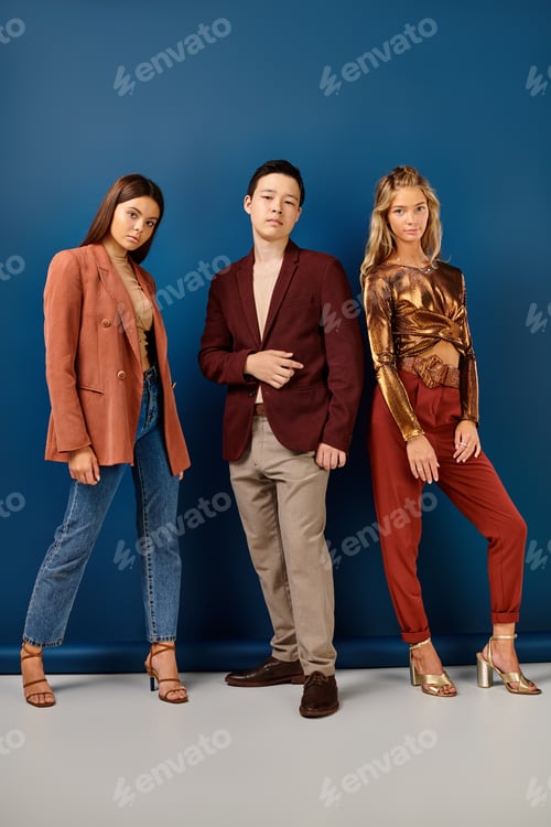 Preview: elegant multiracial teenagers in chic attires posing together and looking at camera, friendship day