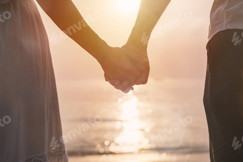 Preview: Young woman traveler holding man's hand and looking beautiful sunset on the beach