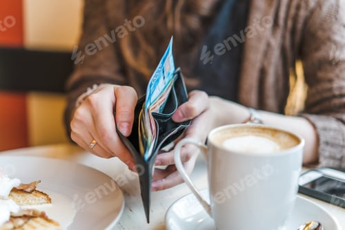 Preview: Holding a wallet with banknotes inside in a cafe
