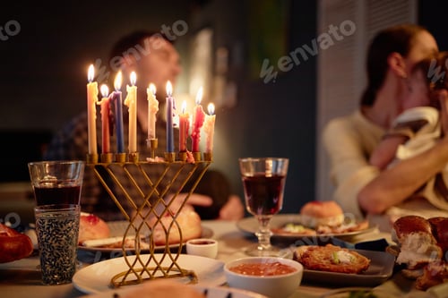 Preview: Family Celebrating Hanukkah Lighting Menorah during Dinner Gathering