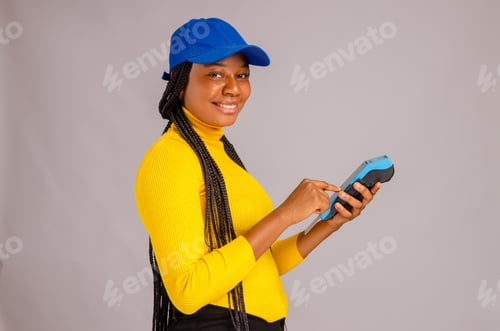 Preview: African lady smiling and holding a payment terminal - the concept of sales