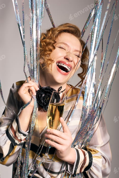 Preview: Joyful young woman celebrating with gifts and champagne amidst sparkling decorations