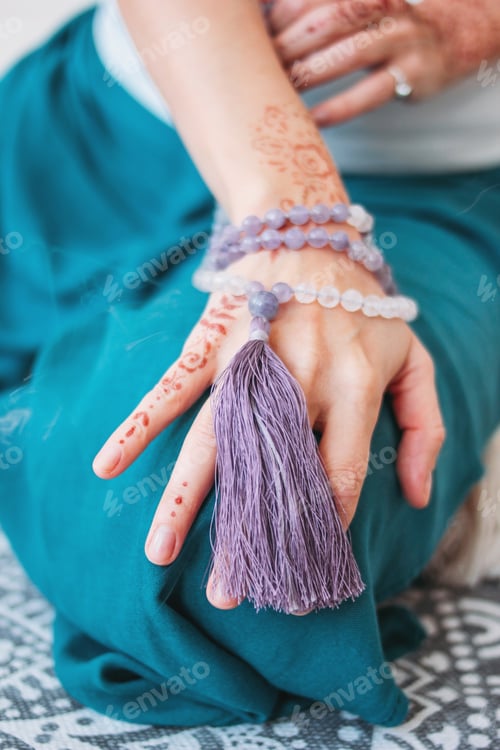 Preview: Woman with lilac mala beads on her hands henna mehendi