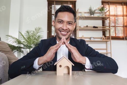 Preview: Real estate concept, businessman holds house icon. House in hand. Property insurance and security