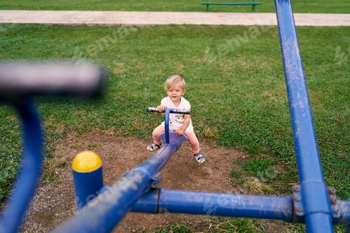 Preview: Little girl swinging on a balance swing in the playground