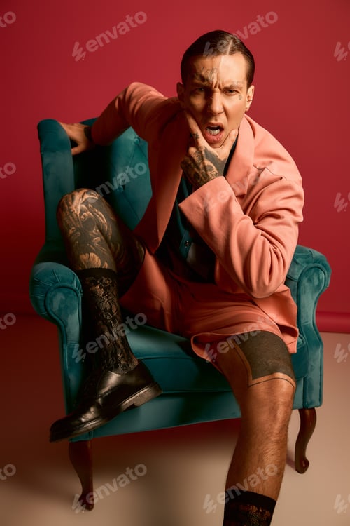Preview: Stylish young man in a pink suit posing confidently in a vibrant setting