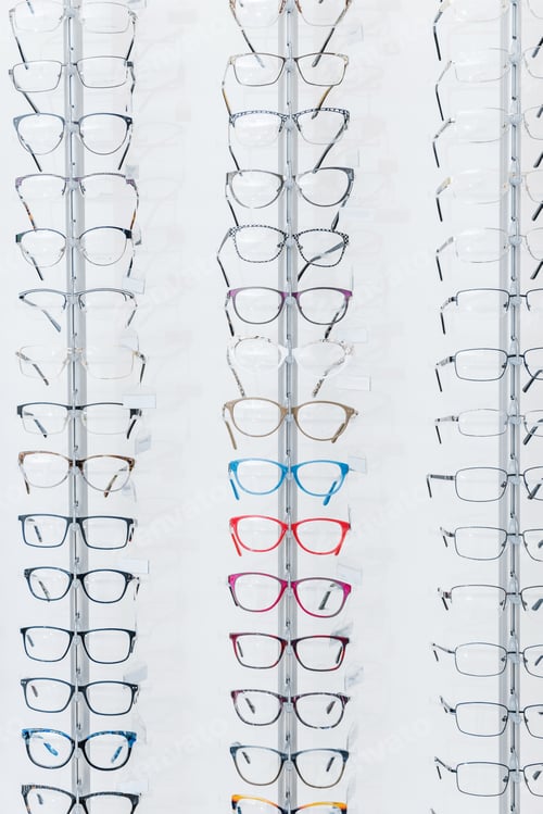 Preview: background with different eyeglasses on shelves in optics