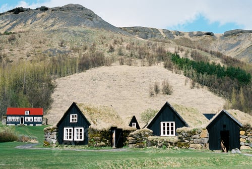 Preview: Black wooden houses with moss-covered roofs in a mountain valley. Iceland
