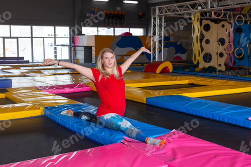 Preview: fitness, sport, exercising, stretching and people concept - smiling woman doing splits on mat over
