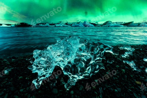 Preview: Aurora borealis, Northern lights glowing over abstract iceberg in Jokulsarlon glacier lagoon