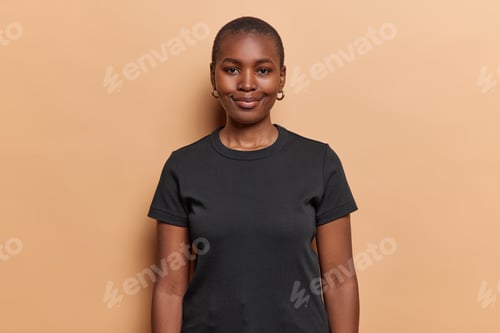 Preview: Waist up shot of dark skinned woman has satisfied expression looks happily at camera dressed in