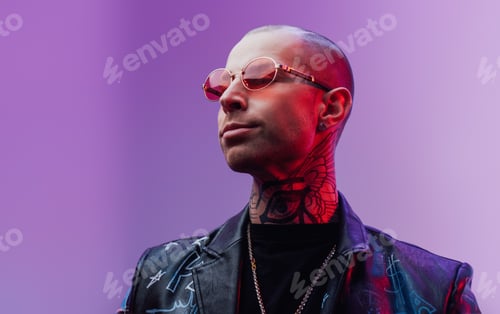 Preview: Tattooed guy in leather jacket poses in bright background